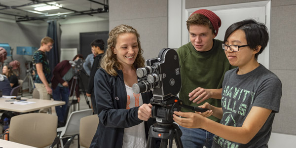 three students around camera